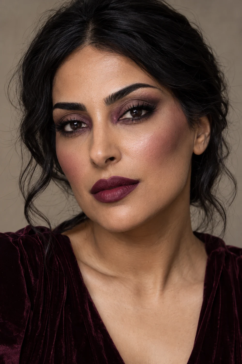 Adult woman with deep plum inner-corner shadow, soft brown lash-line definition, muted plum blush, and deep berry lipstick.