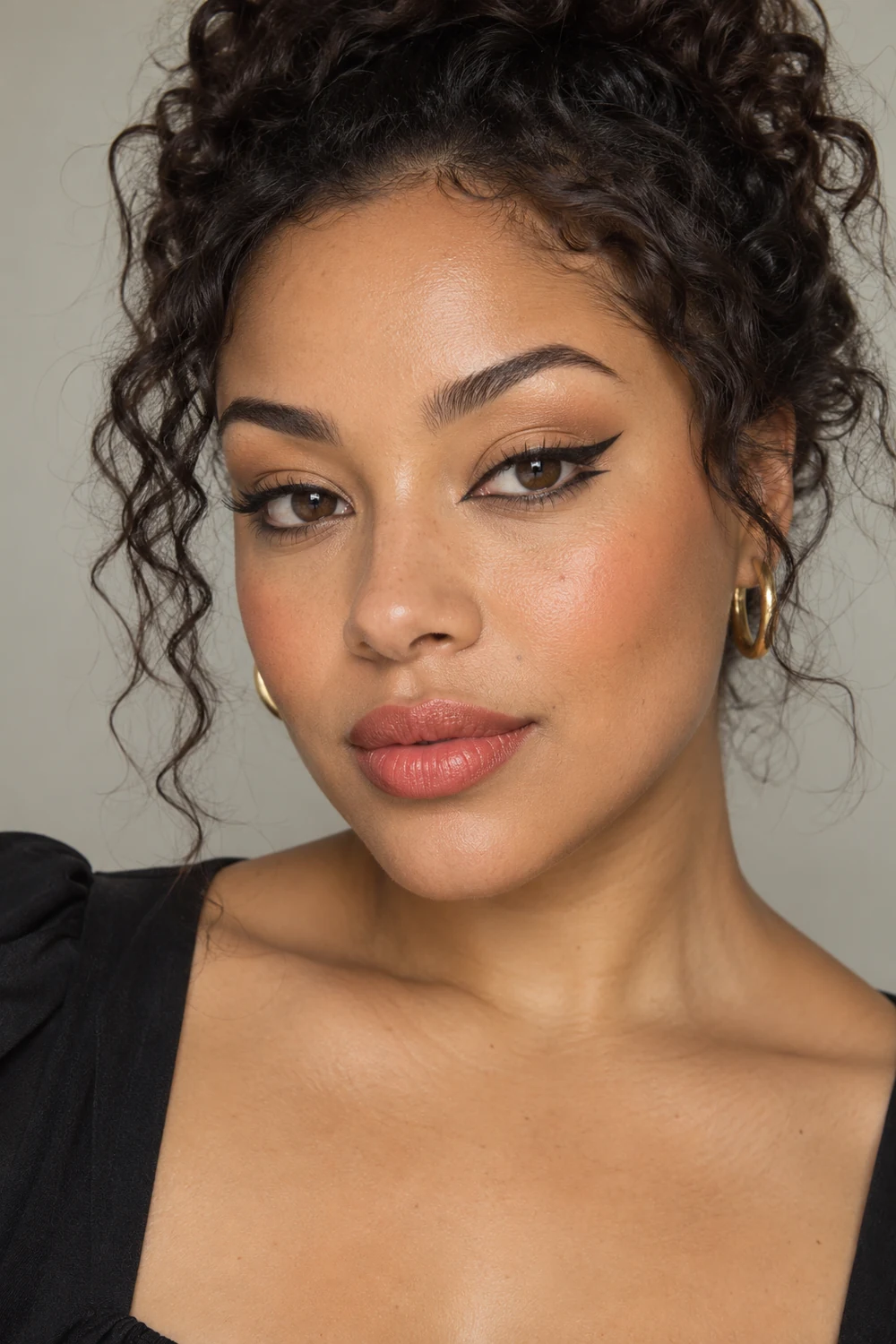 Close vertical portrait of a fictional adult woman with matte sand shadow, a black upper wing and separated lower flick, low apricot blush, and muted coral satin lipstick.