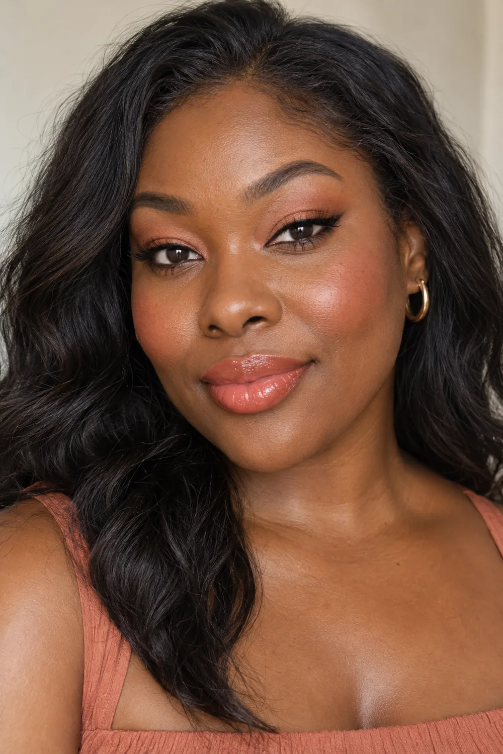Fictional adult Black woman with open hooded dark brown eyes wearing warm peach shadow, a short brown wing, peach-rose blush, and glossy coral lips.