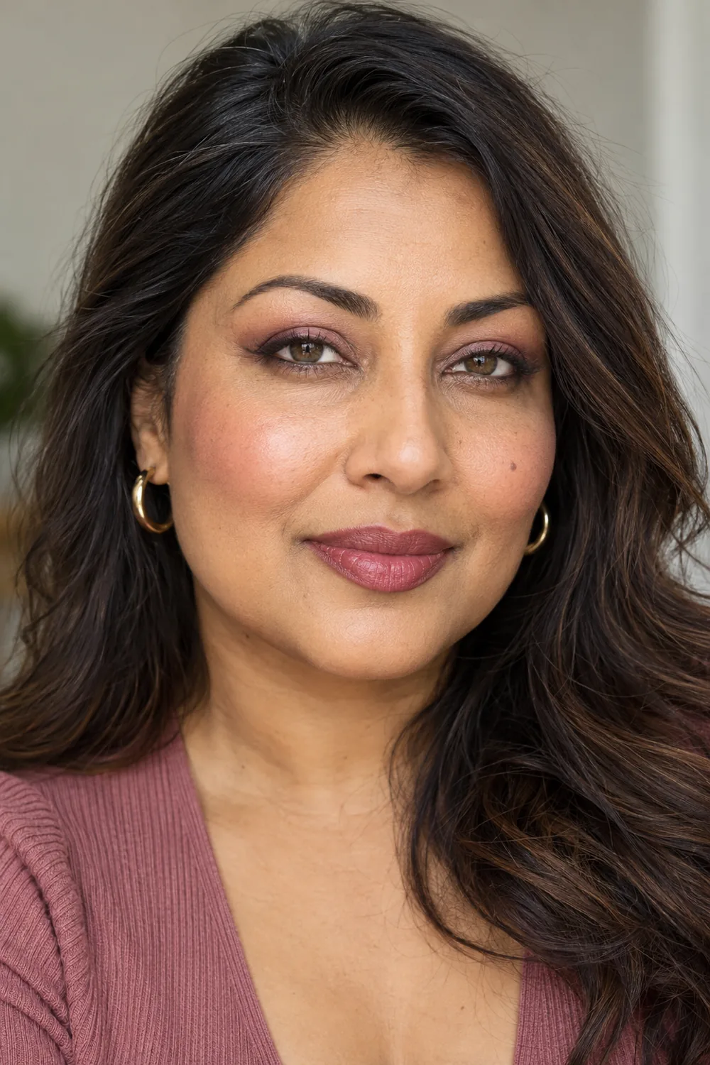 Fictional adult South Asian woman with open hooded hazel-brown eyes, dusty rose and rose-brown shadow, softly smudged plum-brown liner, pink blush, and rose-mauve lips.