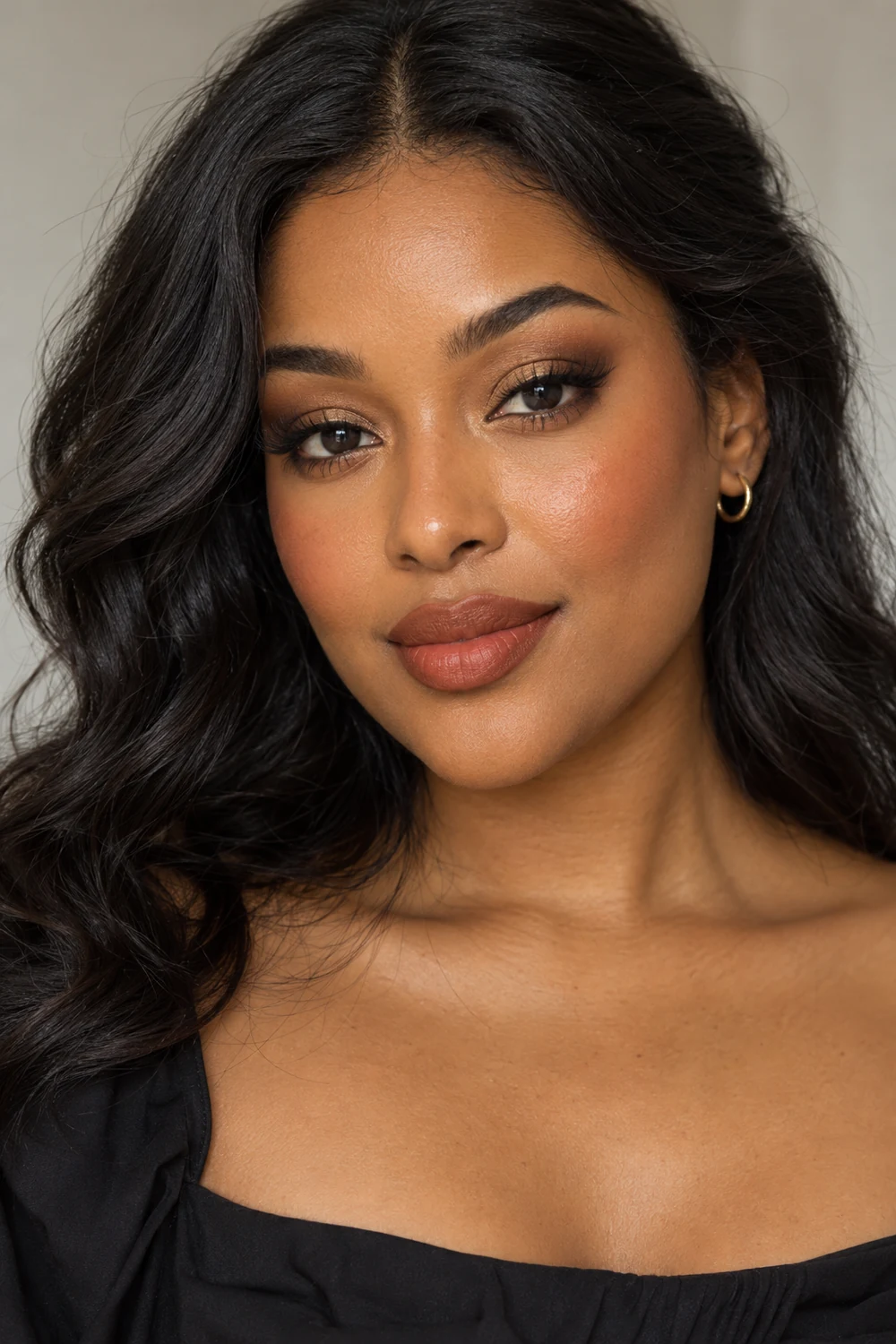 Adult woman with matte golden-brown eye shadow, softly smoked liner, apricot-bronze blush, and terracotta lips in a soft matte finish.