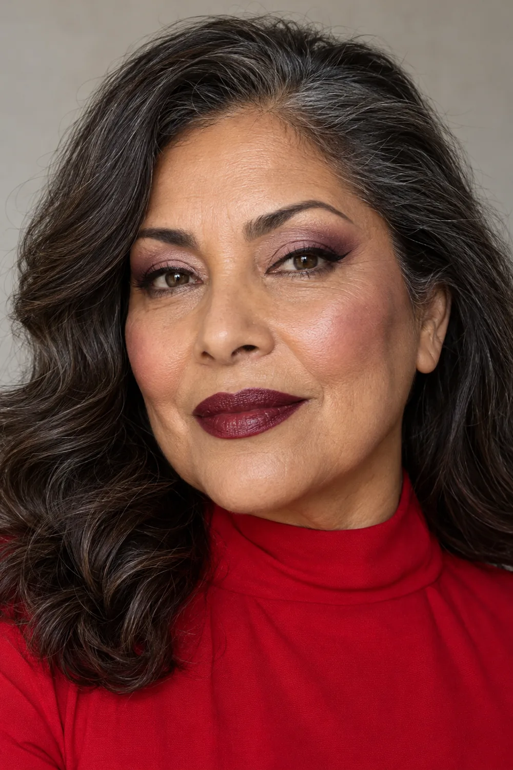 Fictional adult woman with mature features wearing a high-neck red dress, angled plum eye shadow, a black wing, mauve blush, and deep plum lipstick.