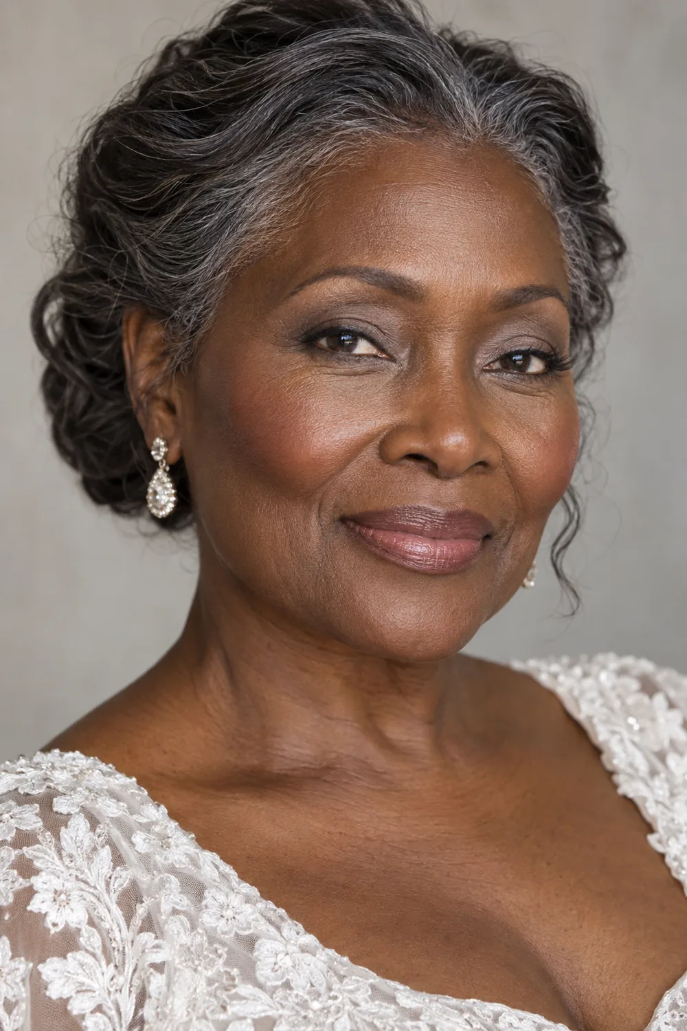 Mature East African woman in bridal-style clothing with dove-gray eyeshadow, fine charcoal-brown liner, pink-brown blush, and satin pink-brown lips.