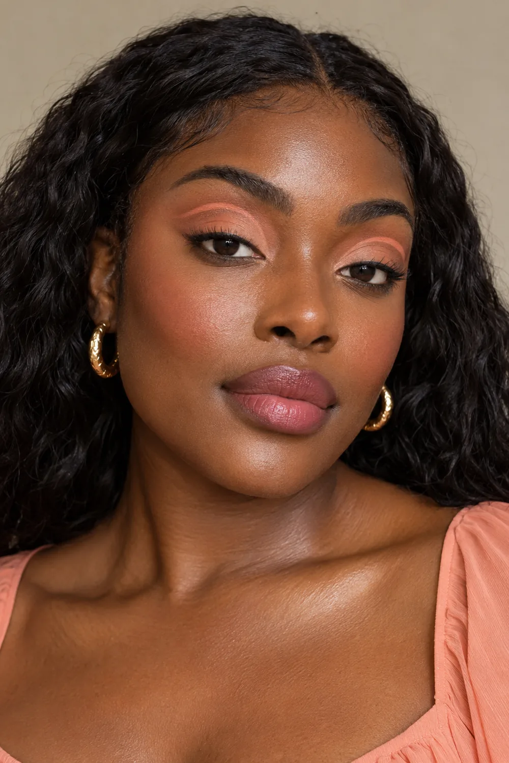 Portrait of a Black woman with a peach floating crease line, matte peach lids, soft peach blush, and mauve-rose lips.