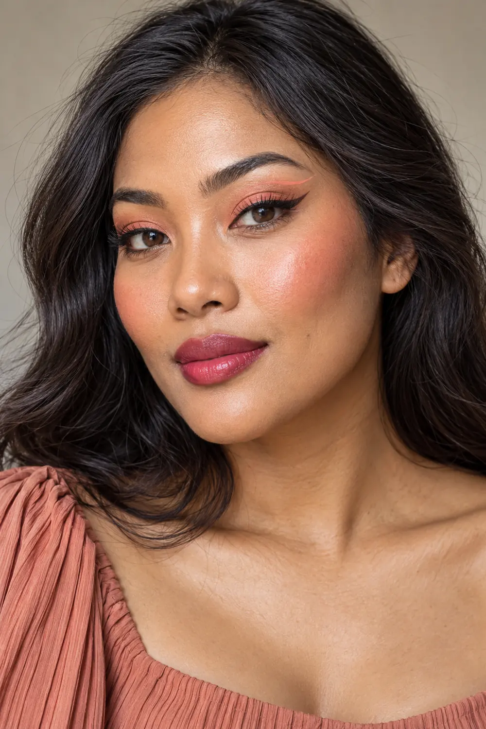 Fictional adult woman with apricot lids, a dark brown wing and separate peach graphic crease line, vivid high cheek blush, and berry lips.