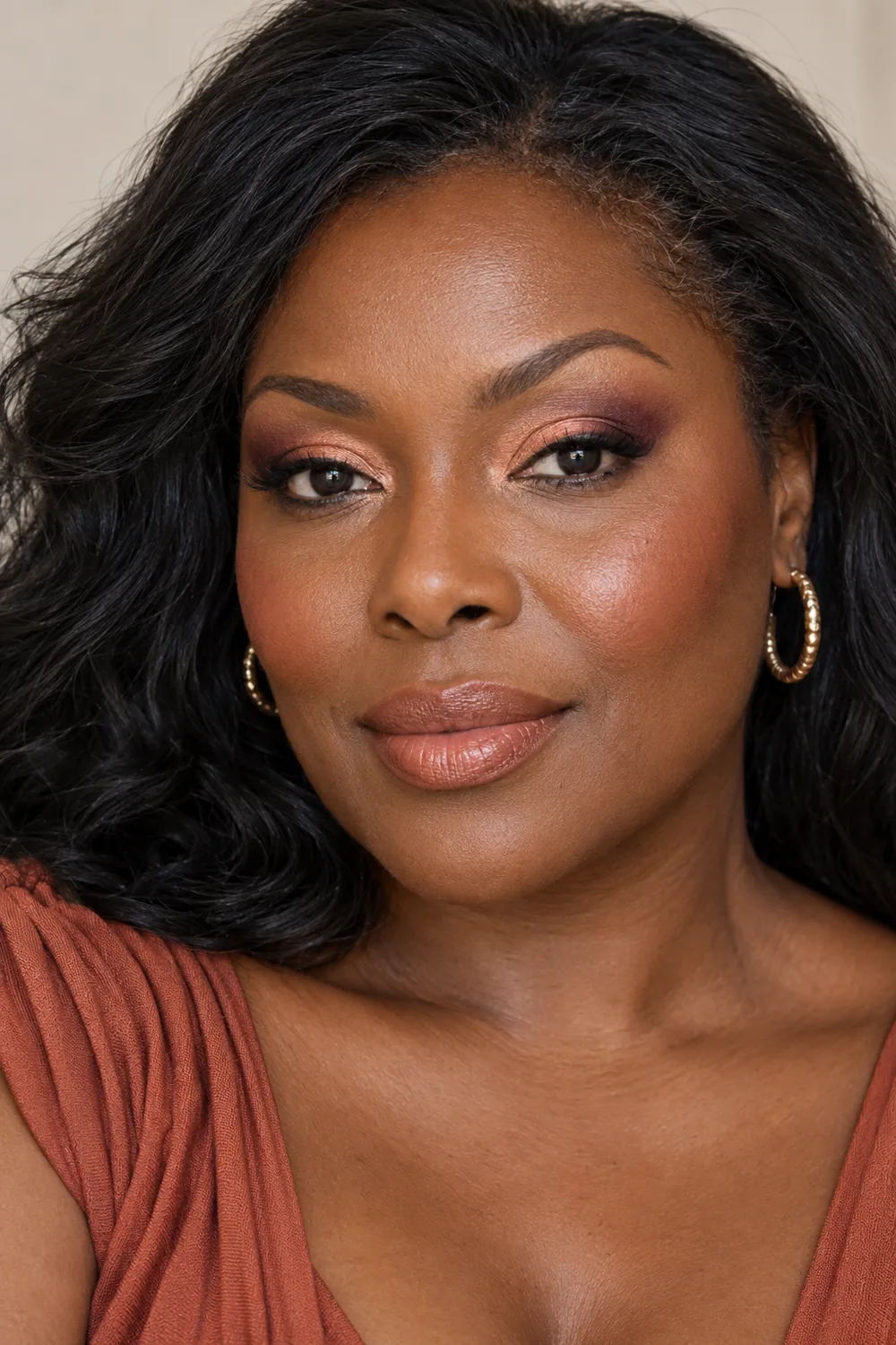 Photorealistic close portrait of an adult Black woman wearing peach inner-lid shimmer, plum outer-corner shadow and liner, sheer peach blush, and muted peach-brown satin lipstick.