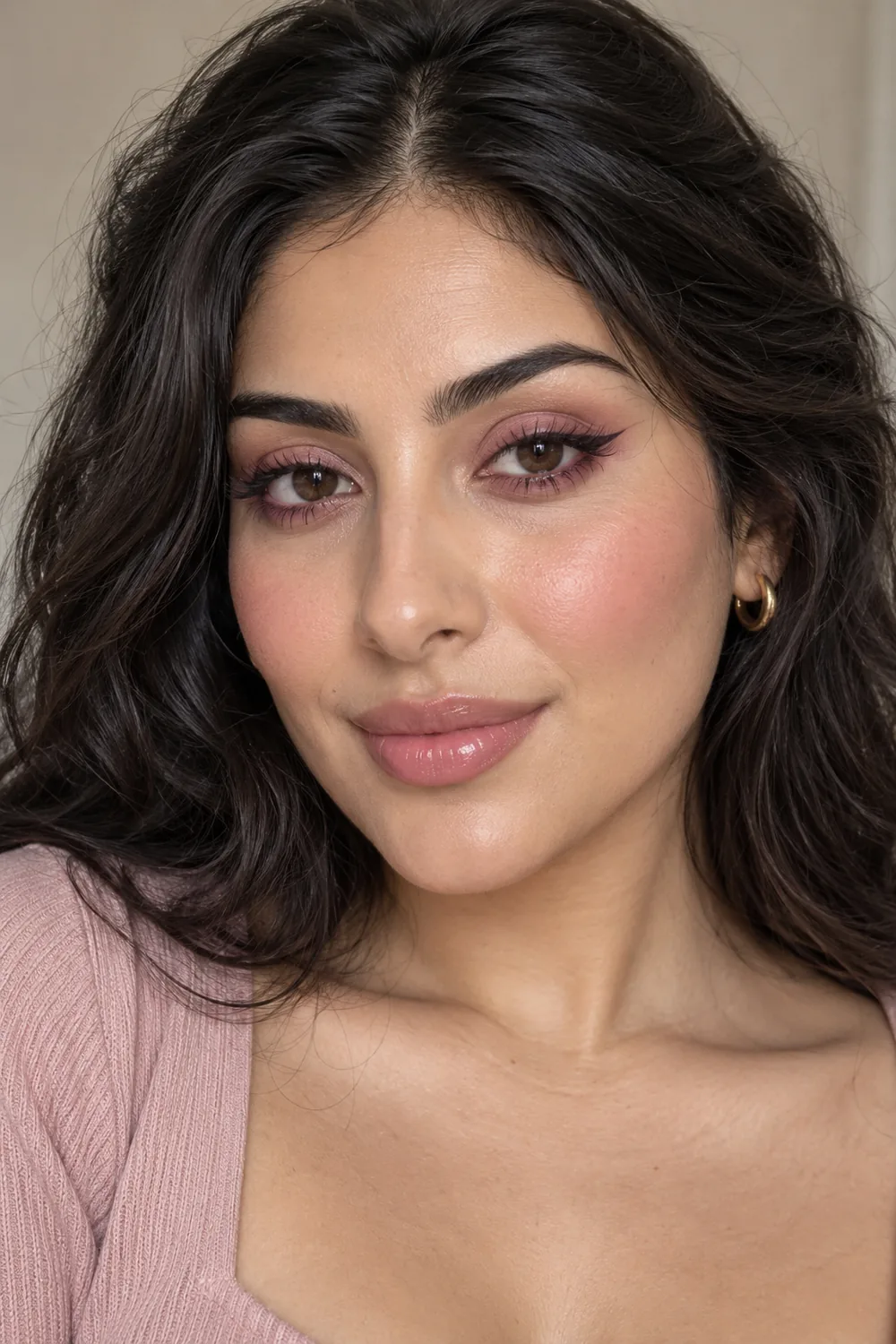 Vertical beauty portrait of an adult woman with a matte pink lid wash, rose lower-lash smudge, small dark liner flick, rosy cheek blush, and translucent pink balm.