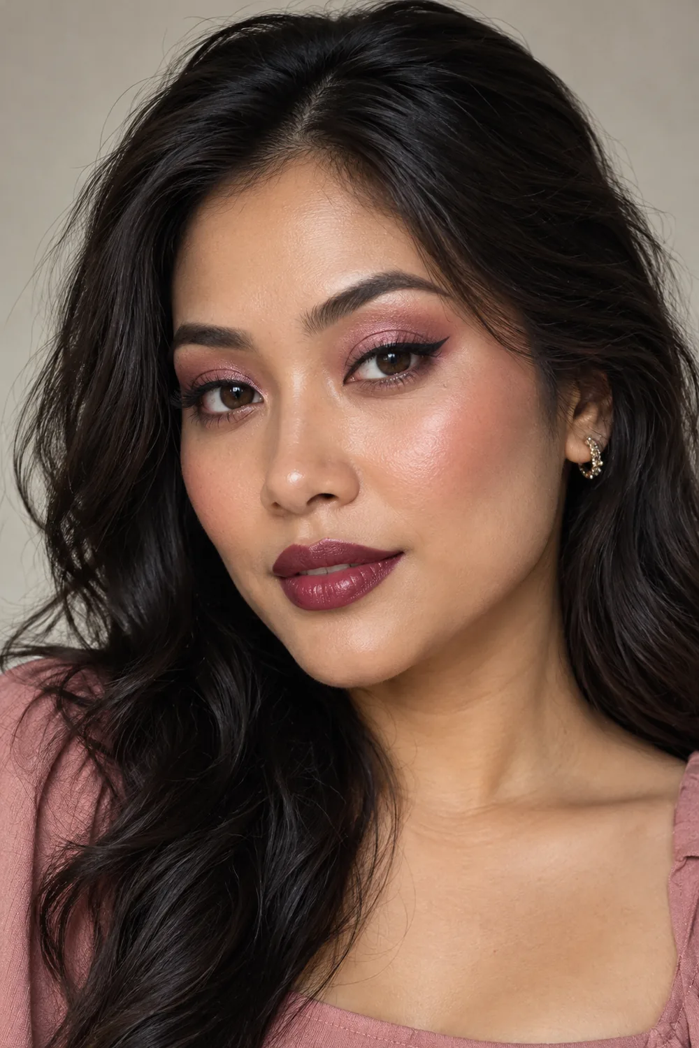 Adult woman with warm medium skin, glossy rose-pink lids, a short black wing, rosy cheekbone blush, and deep berry satin lipstick.