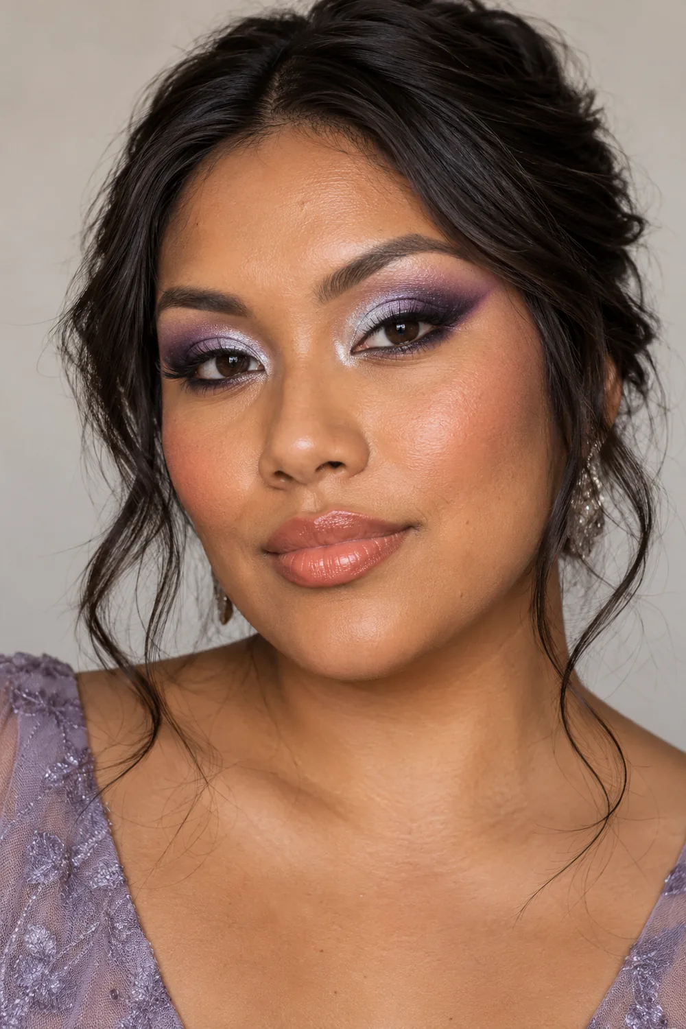 Fictional adult woman with copper-brown skin wearing silver inner-lid shadow, lilac and violet blended wings, coral blush, and peach-toned lips.