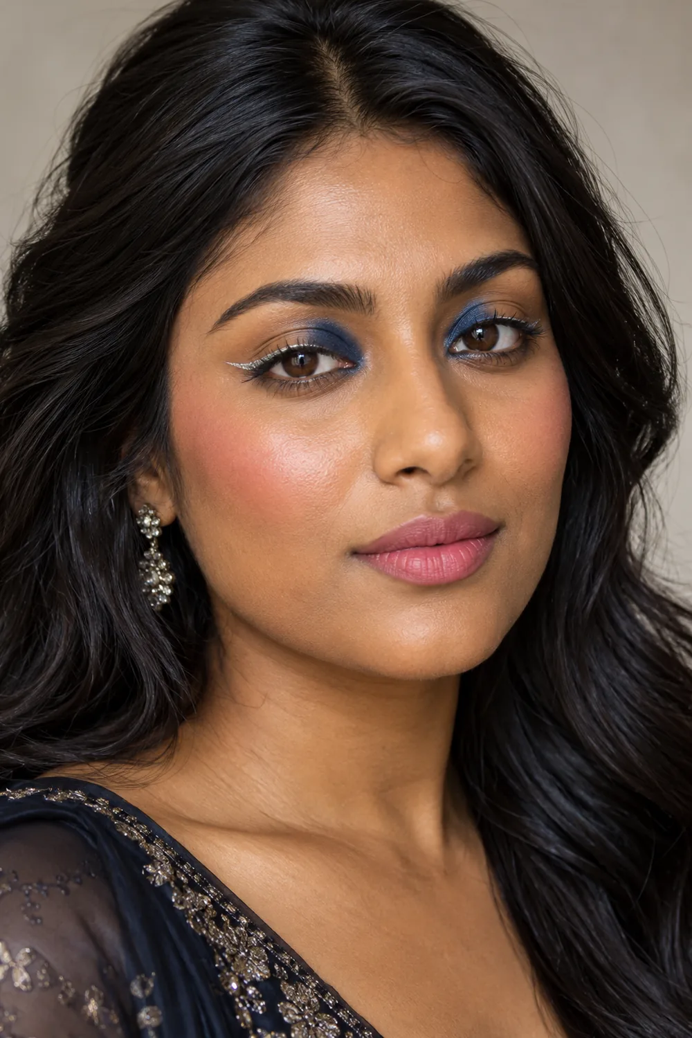 Photorealistic close portrait of an adult South Asian woman wearing navy inner-half eyeshadow, silver mid-lash eyeliner with short flicks, berry blush, and soft pink matte lipstick.